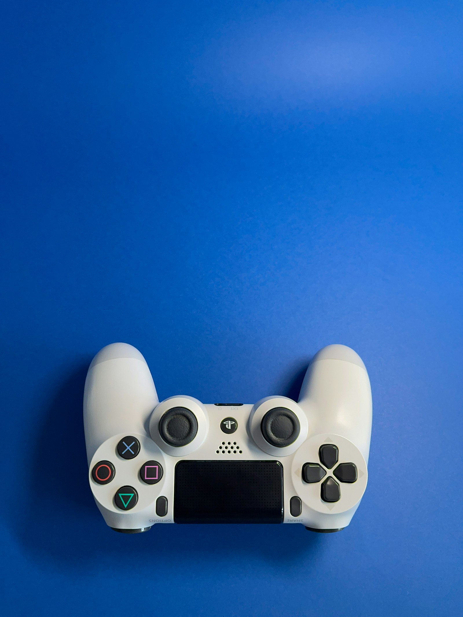 White game controller on a bright blue background.
