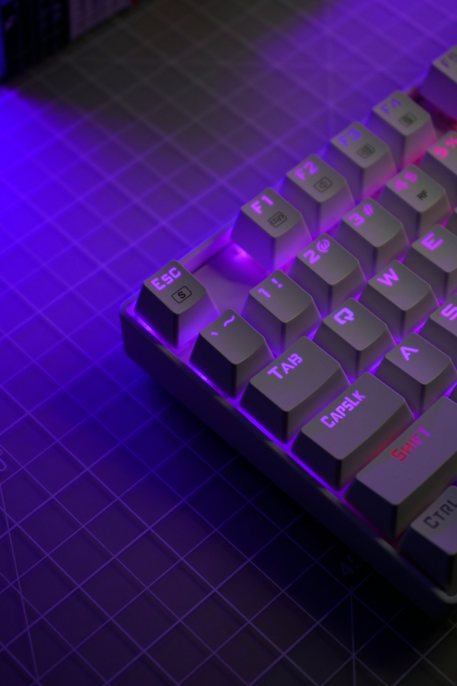 Purple-lit gaming keyboard on a desk.